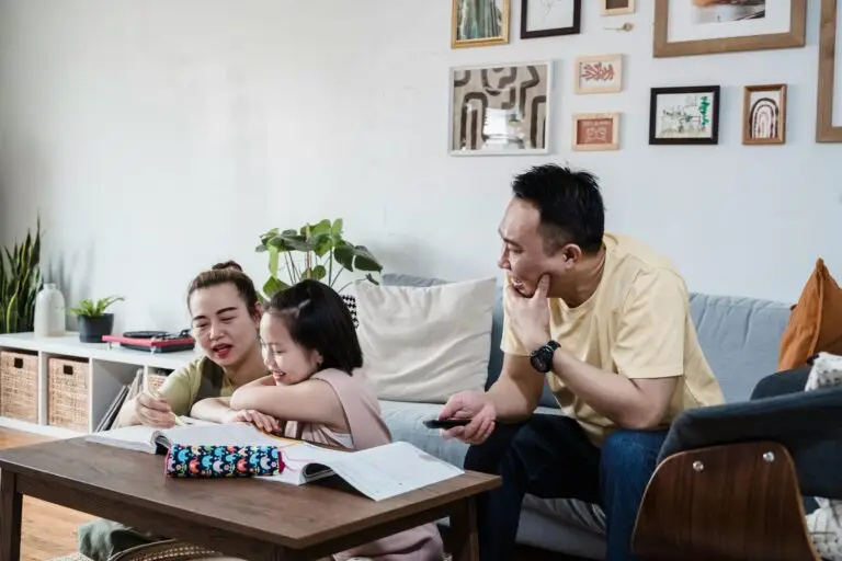 A family enjoys quality time studying and writing together in their living room.